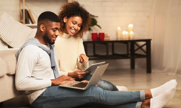 Couple sharing online content on floor