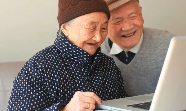 senior couple enjoys using laptop