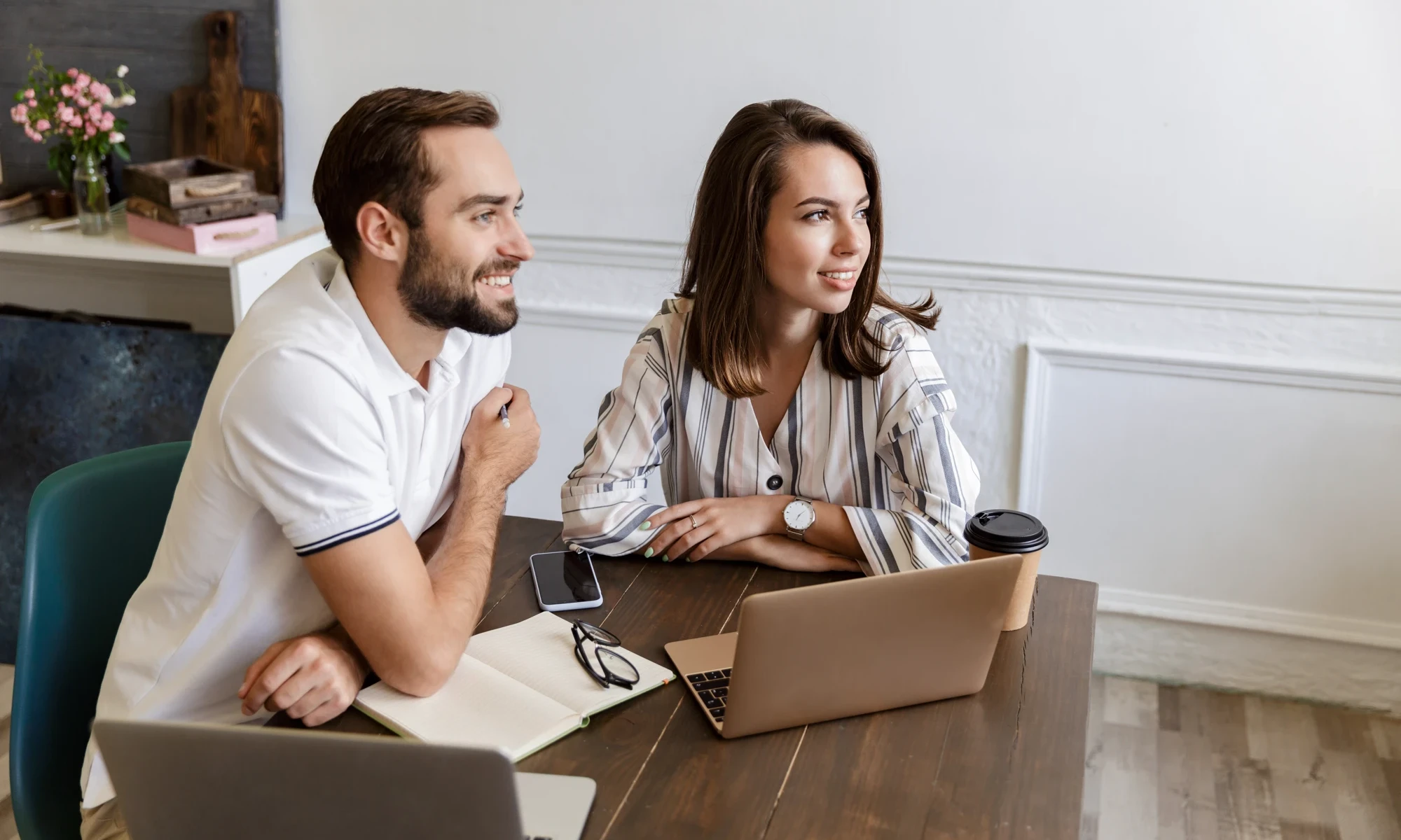 couple plans future with laptop and journal