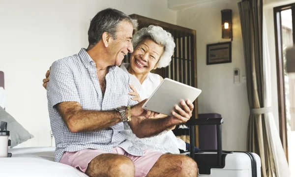 old couple smiling while making travel purchase