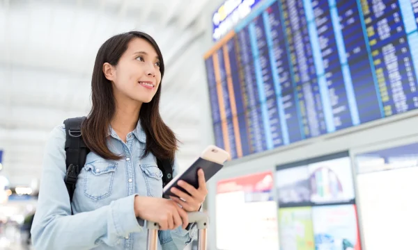 Woman with passport and phone at airport